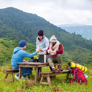 Group of hikers outside sitting at a picnic table